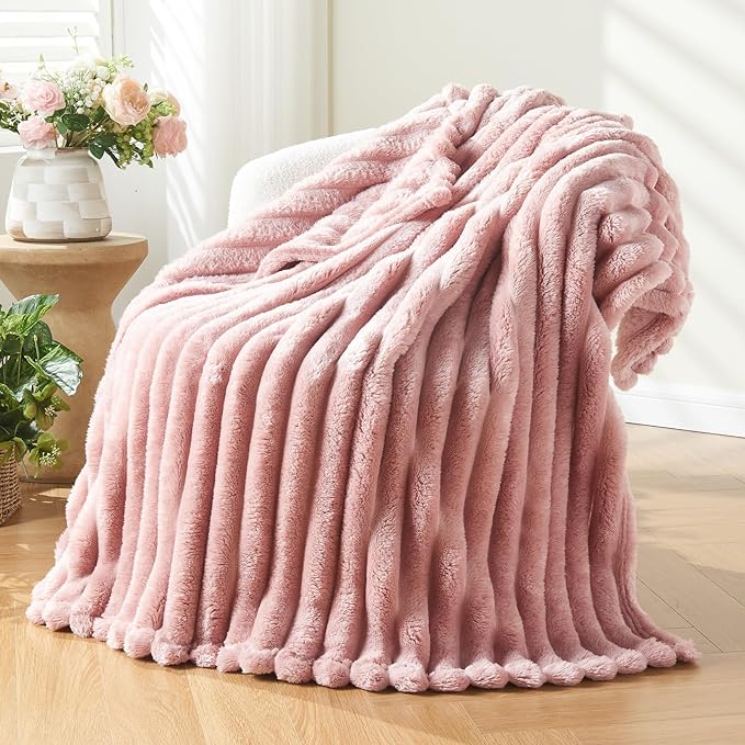 A soft, pink ribbed throw blanket draped elegantly over a chair, showcasing its plush texture and warmth. no-save