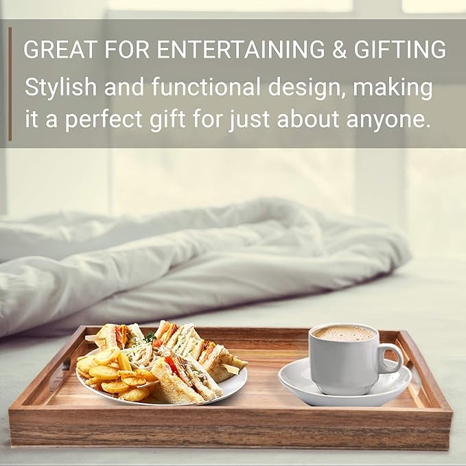 A wooden serving tray with a cup of coffee and a plate of sandwiches and chips, placed on a bed with white sheets in the background. no-save